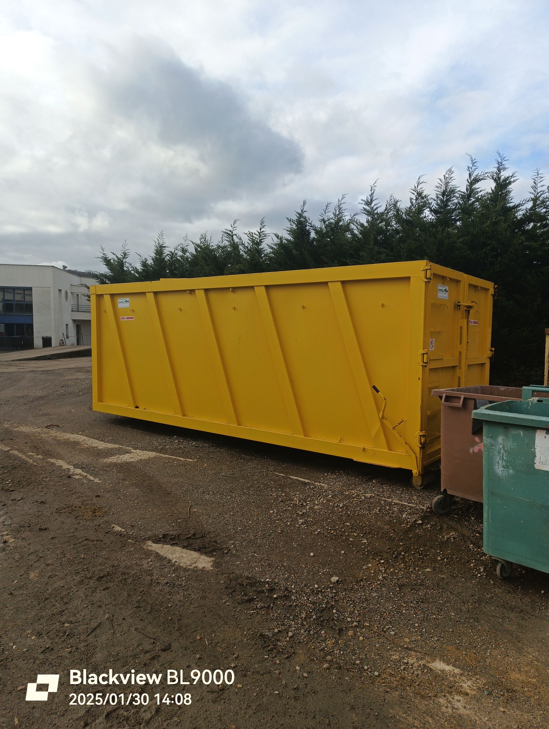 Un container jaune, posé sur un parking