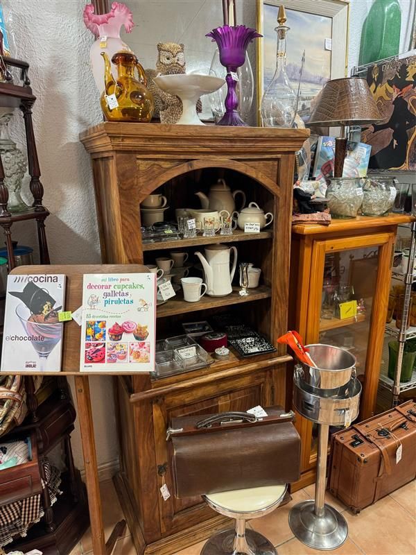 Una habitación llena de muchos muebles antiguos y una silla.