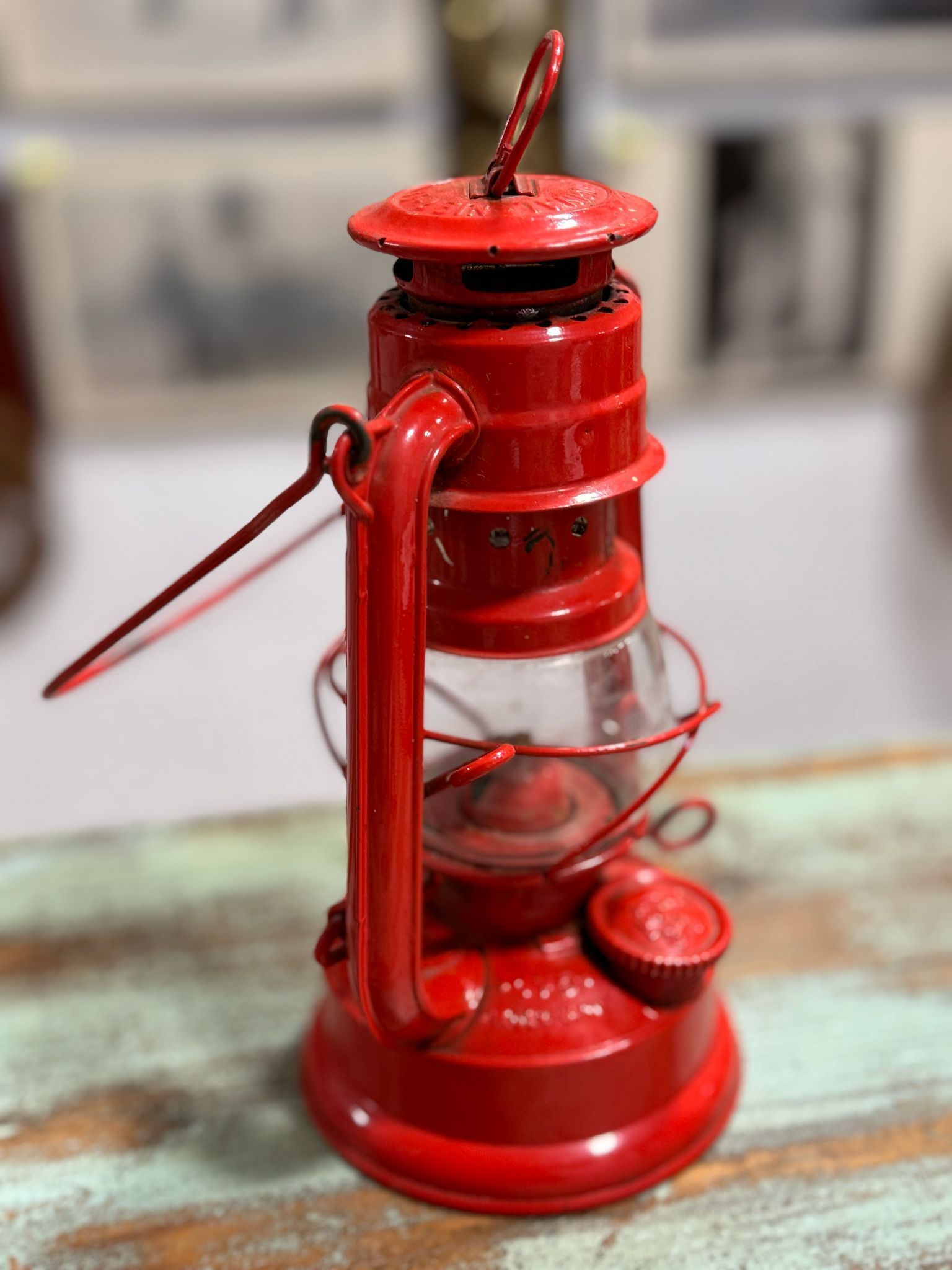 Una linterna roja está sentada sobre una mesa de madera.