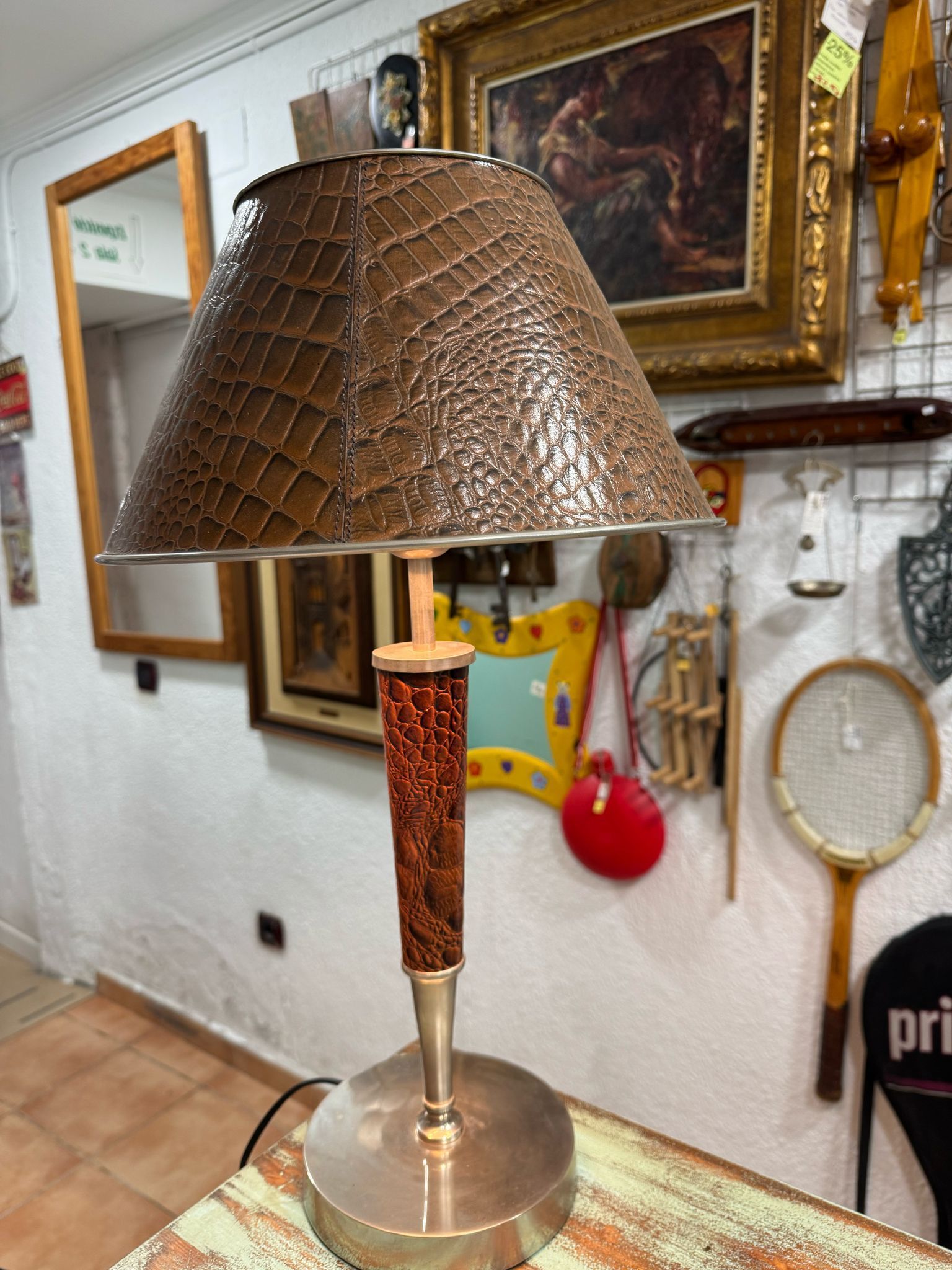 Una lámpara con pantalla marrón está sobre una mesa.