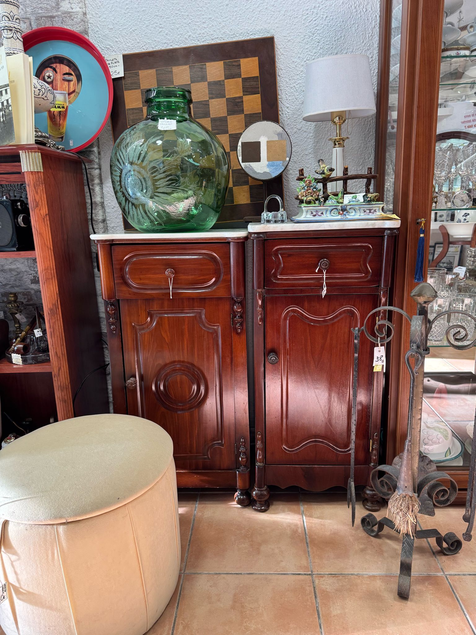Una habitación llena de muchos muebles antiguos y un taburete.