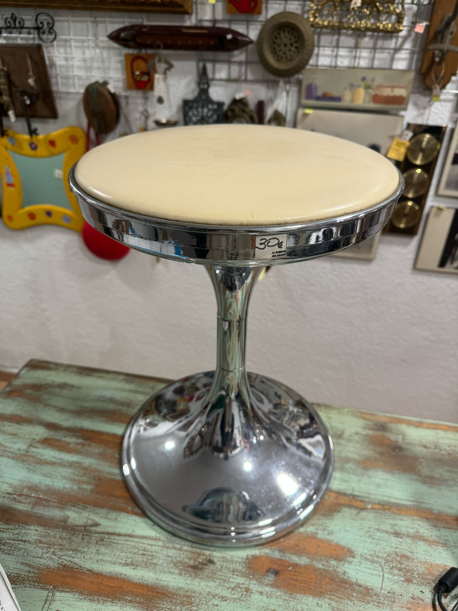 Un pequeño taburete está encima de una mesa de madera.