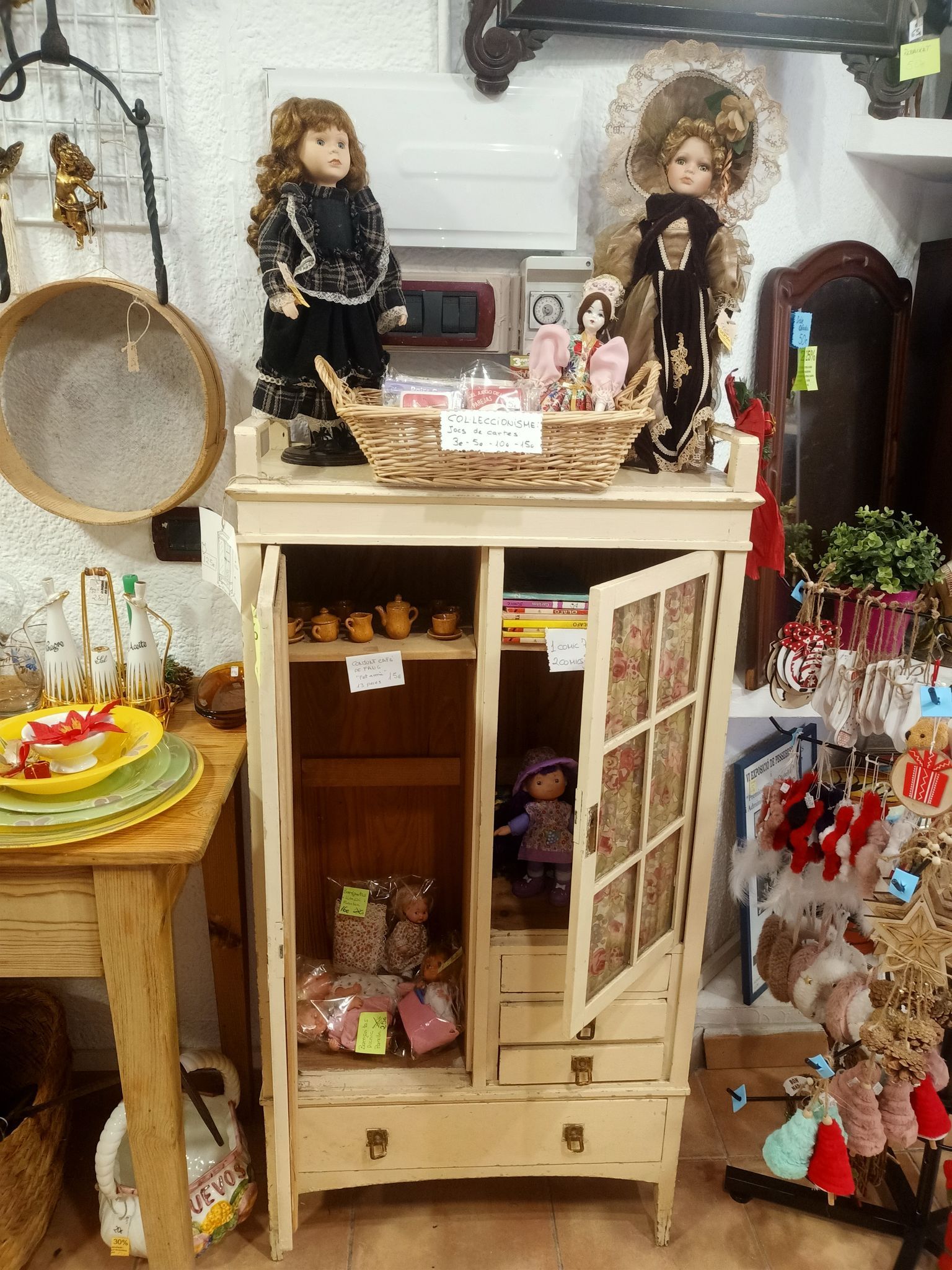 Una muñeca está sentada encima de un armario en una habitación.