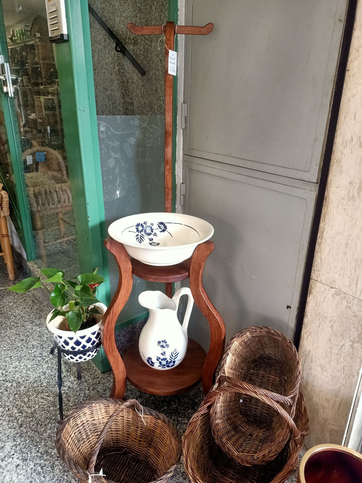 Una mesa de madera con un cuenco, una jarra y cestas sobre ella.