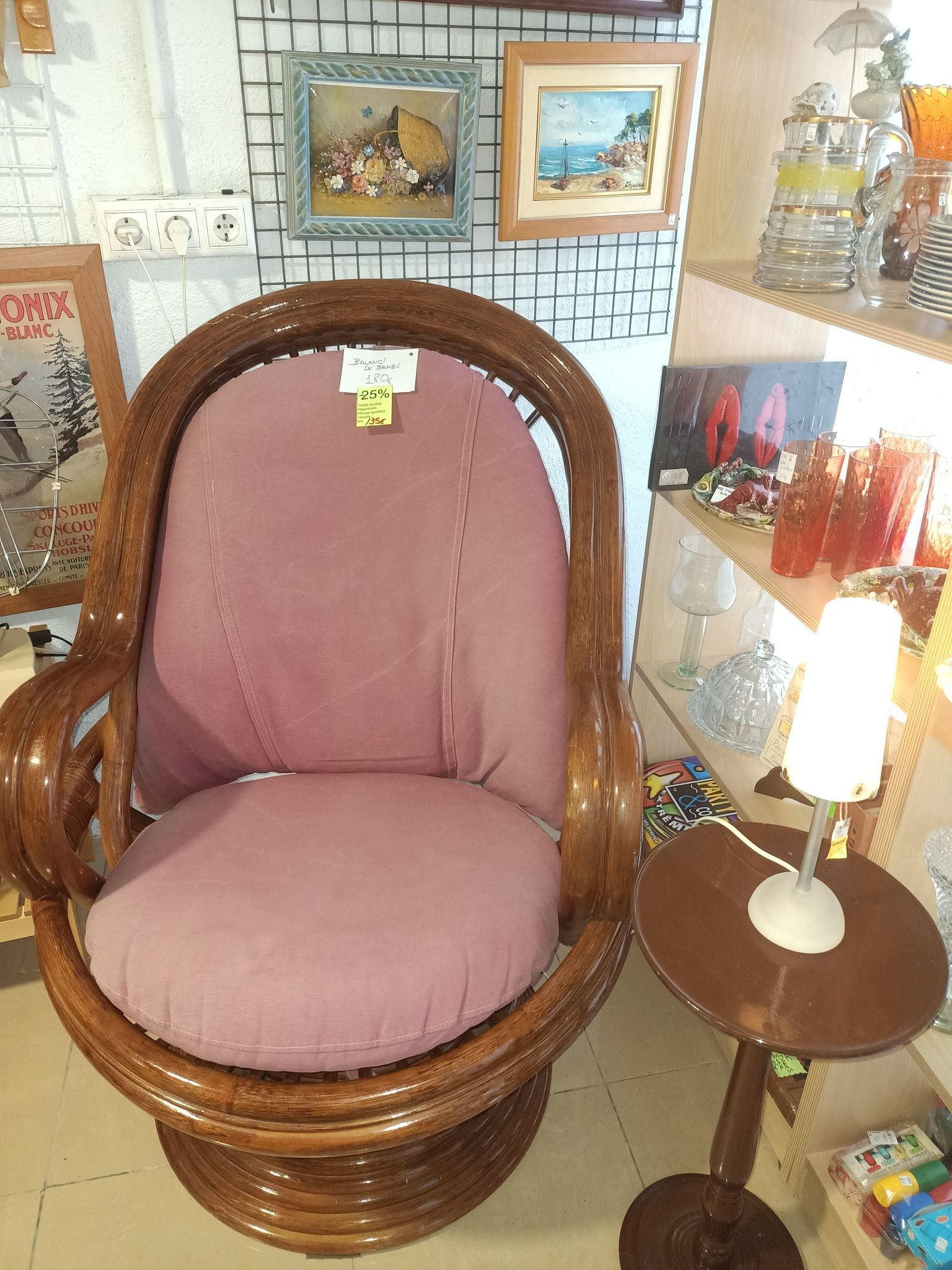 Una silla de mimbre con un cojín rosa en una habitación.