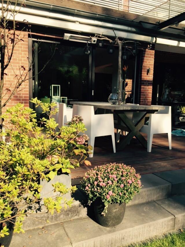 Eine Terrasse mit Tisch und Stühlen vor einem Backsteingebäude
