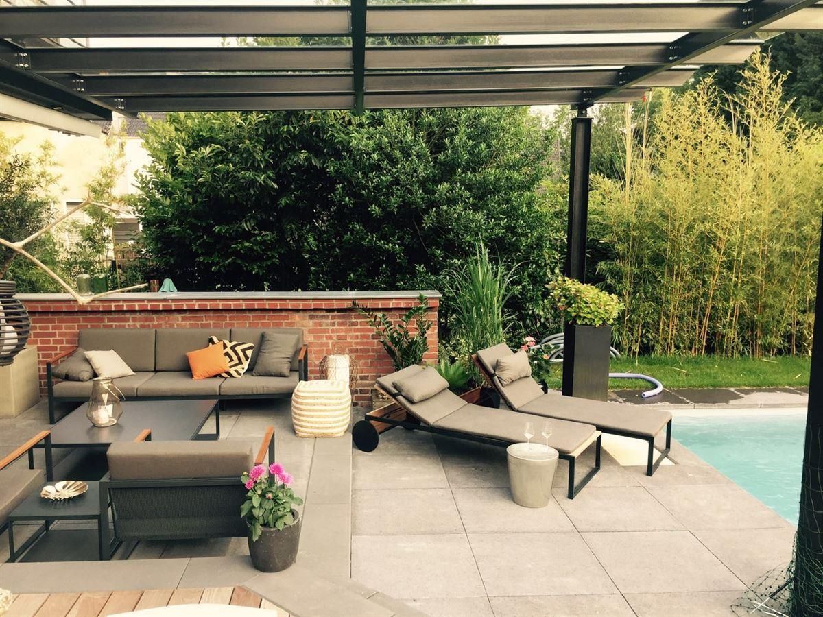 Eine Terrasse mit Sofa und Stühlen neben einem Pool