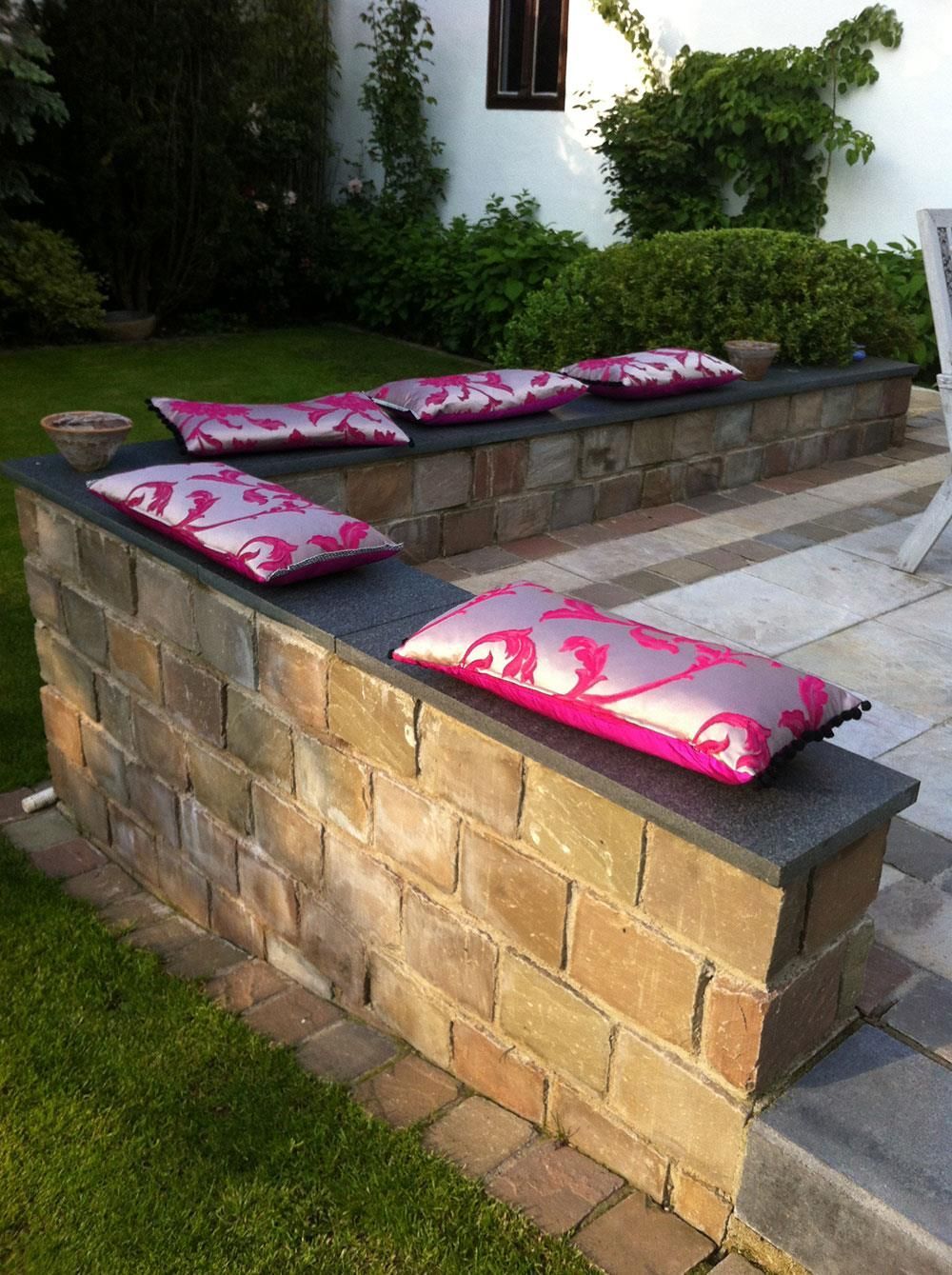 Eine Ziegelwand mit rosa Kissen darauf