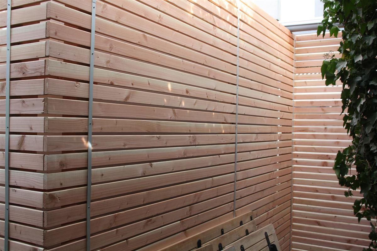 Eine Holzwand mit einer Bank davor