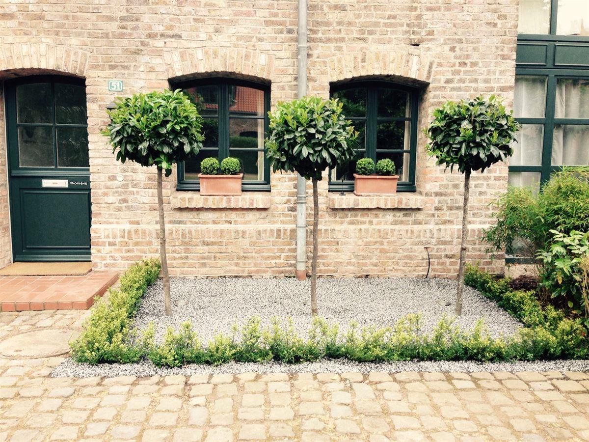 Ein Backsteingebäude mit drei Bäumen davor