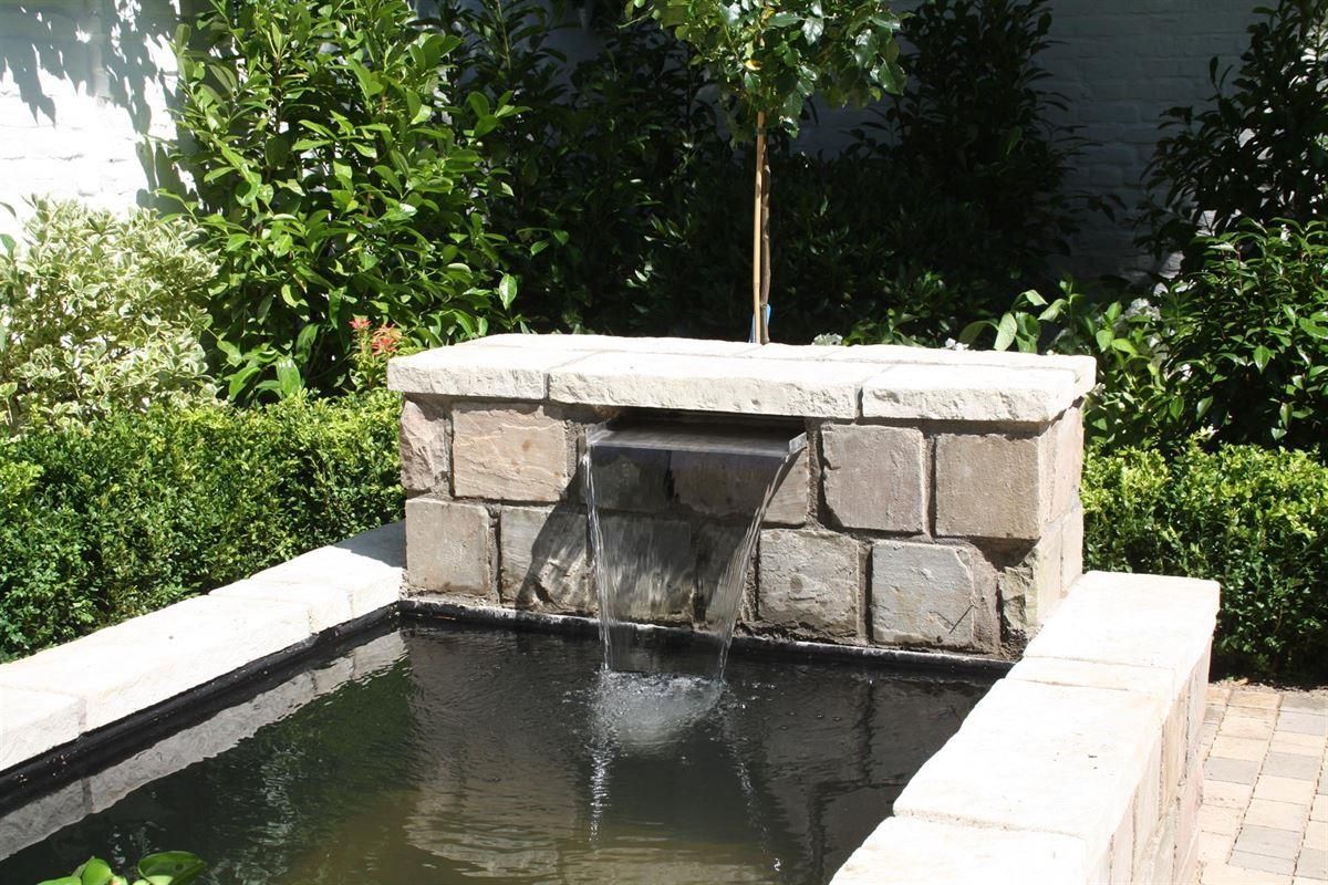 Ein kleiner Teich mit einem Wasserfall in der Mitte