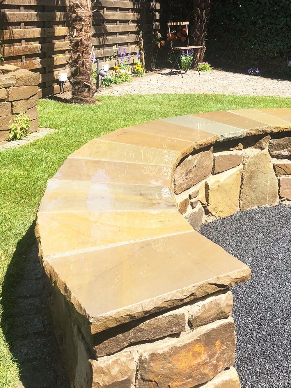 Eine Steinbank steht inmitten eines üppigen grünen Feldes.