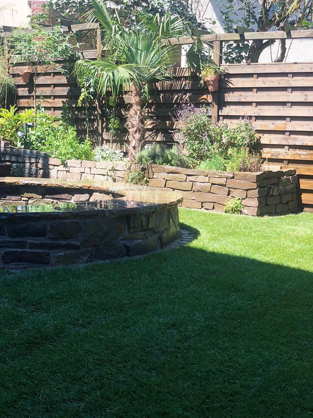 Ein Hinterhof mit einer Feuerstelle und einem Holzzaun