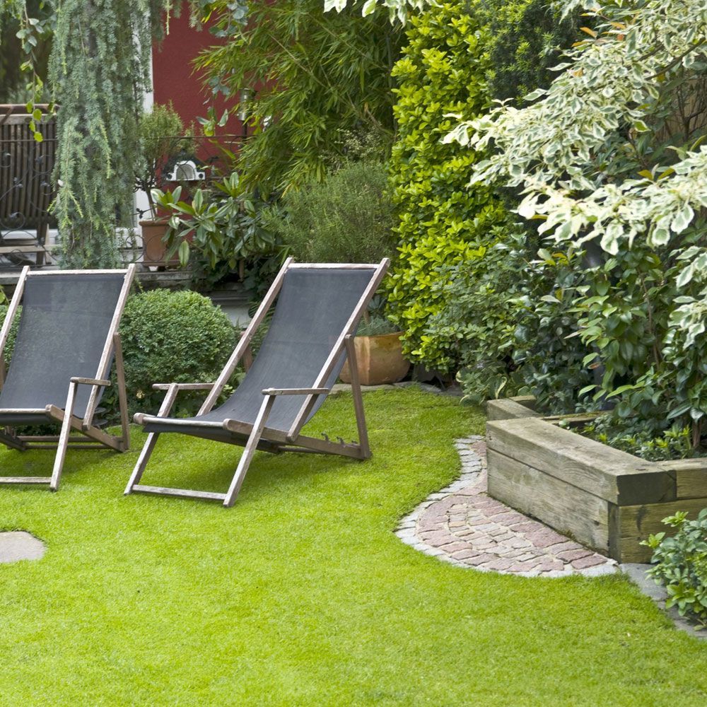 Zwei Gartenstühle stehen auf einem üppigen grünen Rasen