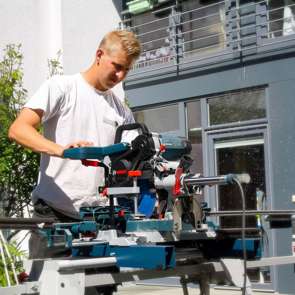 Ein Mann im weißen Hemd arbeitet an einer Maschine