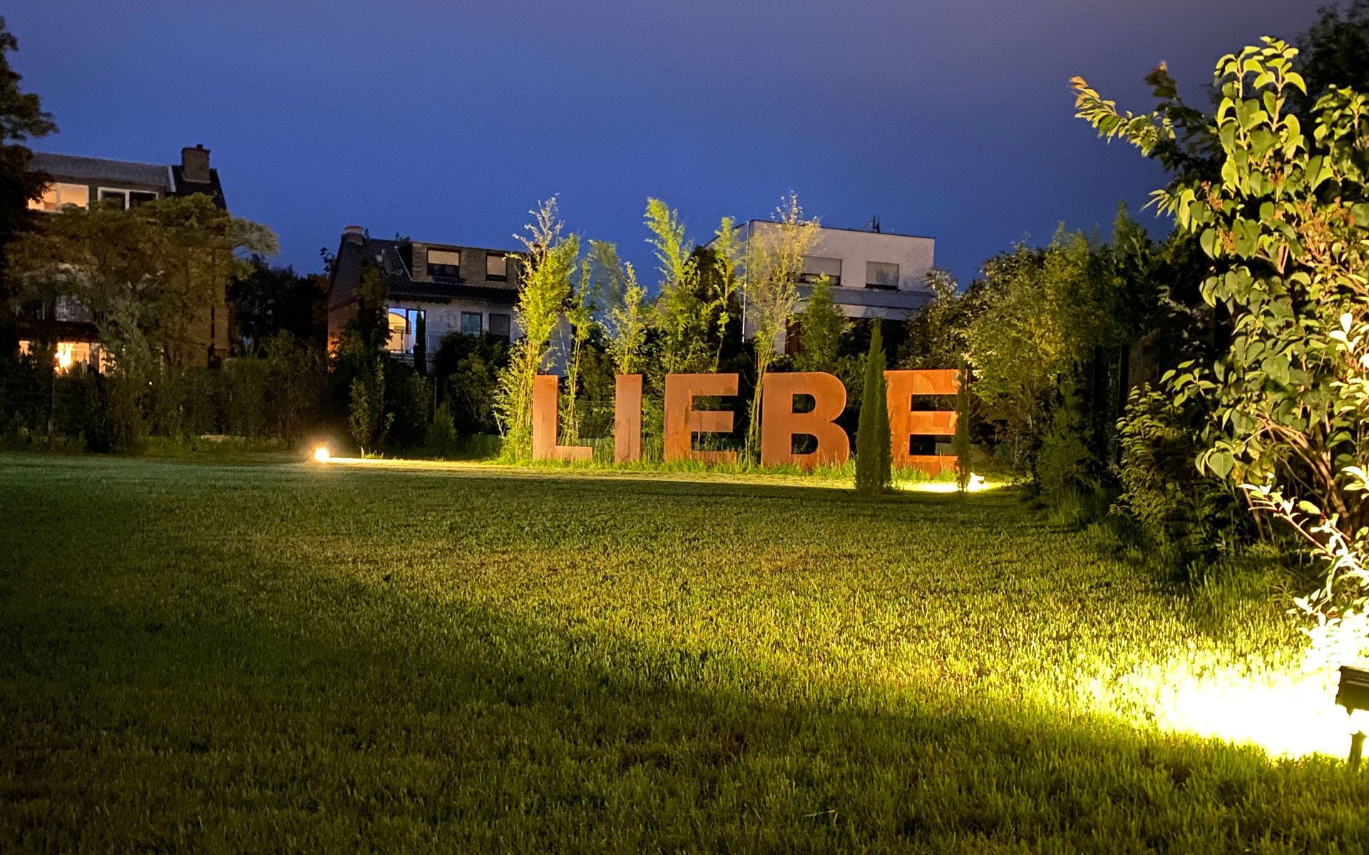 Das Wort Liebe leuchtet nachts im Gras