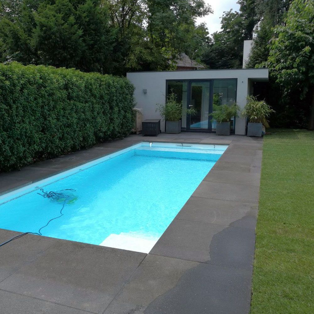 Ein großer Swimmingpool in einem Hinterhof mit einem Haus im Hintergrund