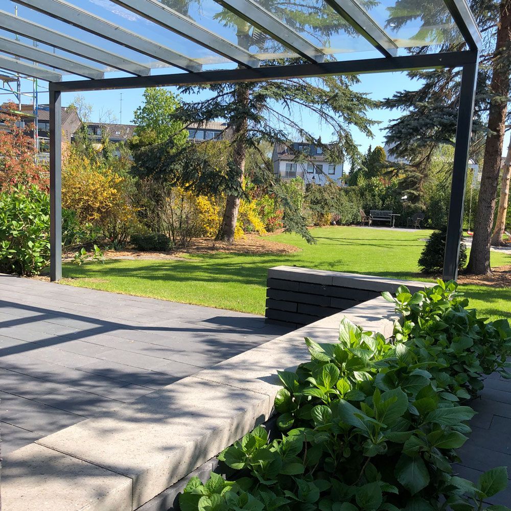 Eine Terrasse mit klarem Dach und Blick auf einen Park
