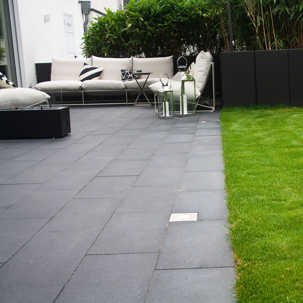 Eine Terrasse mit Sofa, Stühlen und einer Laterne