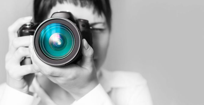 Une femme tient un objectif face à l'observateur