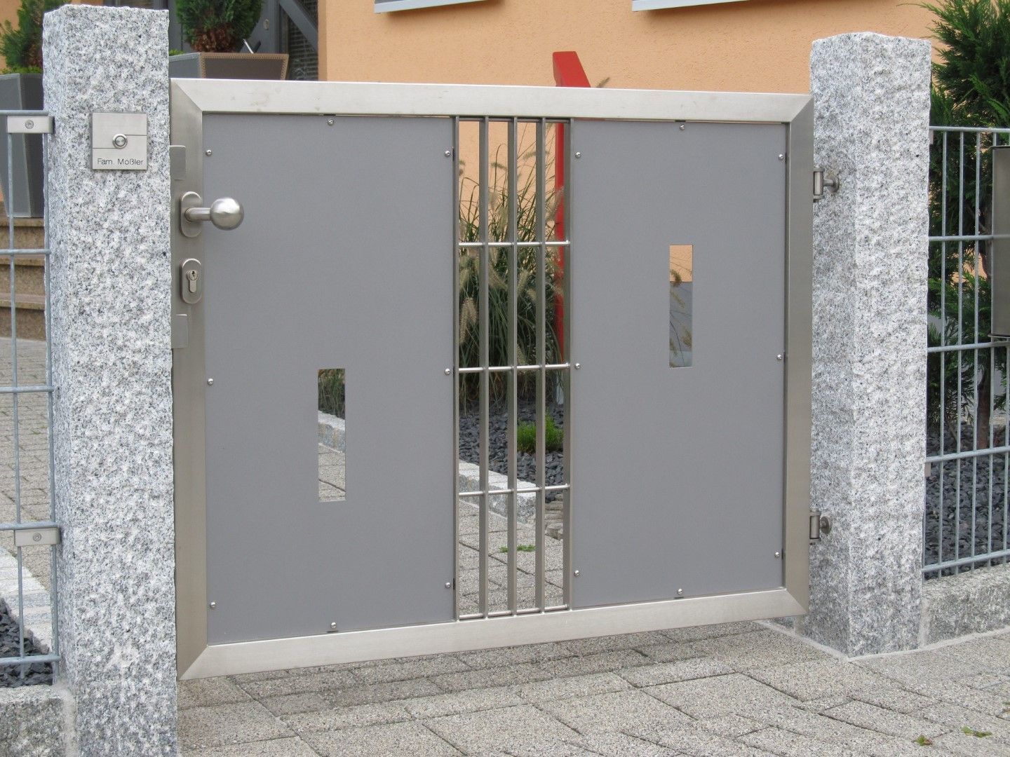 Graues Metalltor mit Gittern, eingefasst in Granitsäulen, mit der Hausnummer 47.