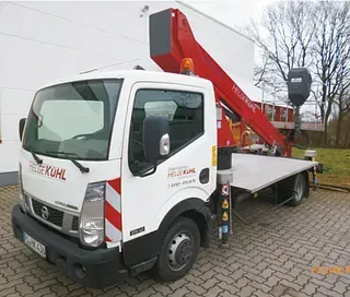 Ein weißer Lastwagen mit einem Kran auf der Ladefläche steht auf einer gepflasterten Auffahrt.