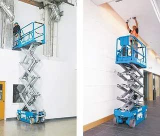 Ein Mann arbeitet in einem Gebäude an einer Scherenbühne.
