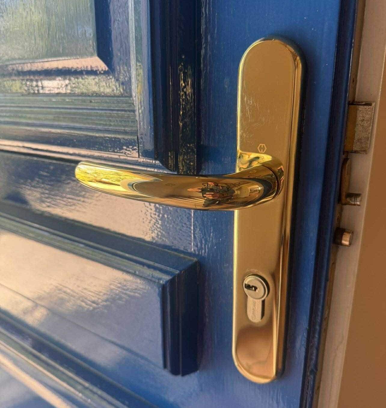 Une poignée dorée sur une porte bleue