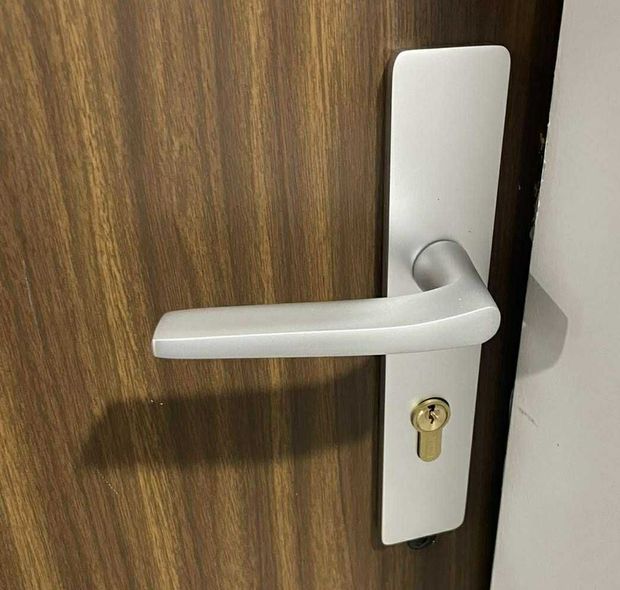 Une poignée de porte sur une porte en bois