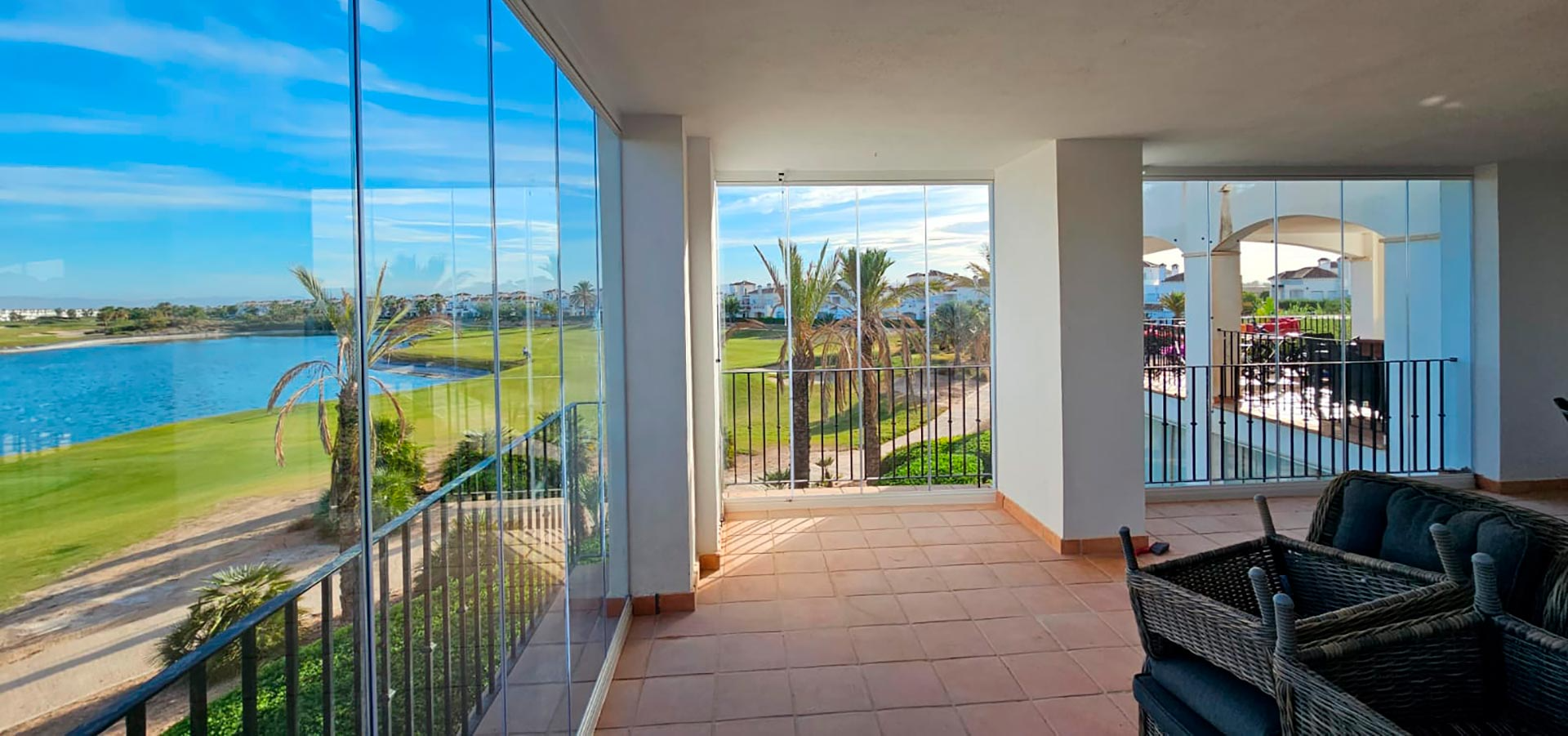 Una habitación grande con muchas ventanas y vista a un lago.