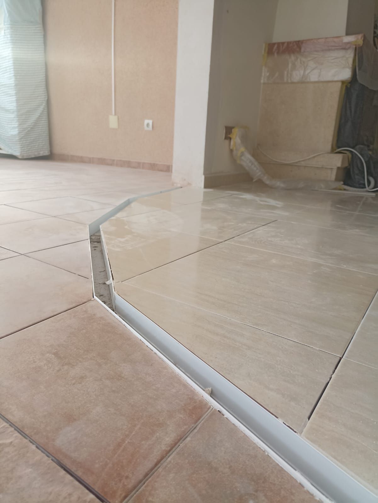 Un piso de baldosas rotas en una habitación con un borde blanco.
