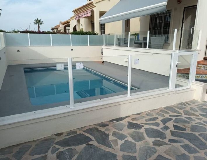 Una piscina con una valla blanca alrededor.