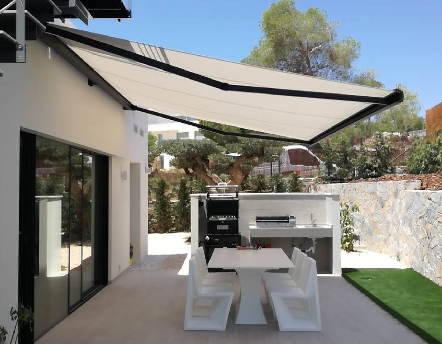 Un patio con una mesa y sillas bajo un toldo.