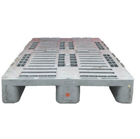 Eine Kunststoffpalette mit Löchern steht auf einer weißen Fläche.