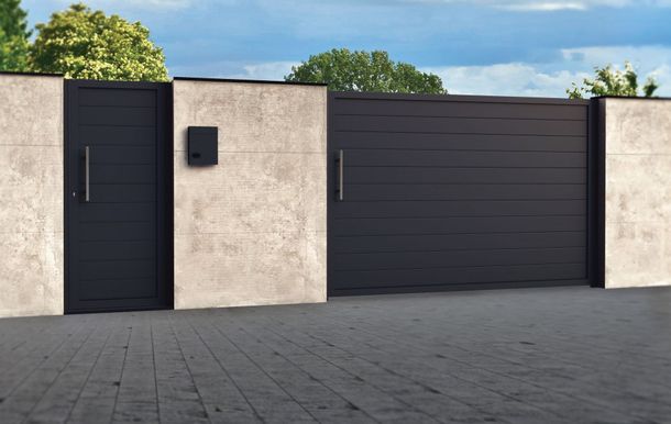 Una valla con una puerta y un buzón encima