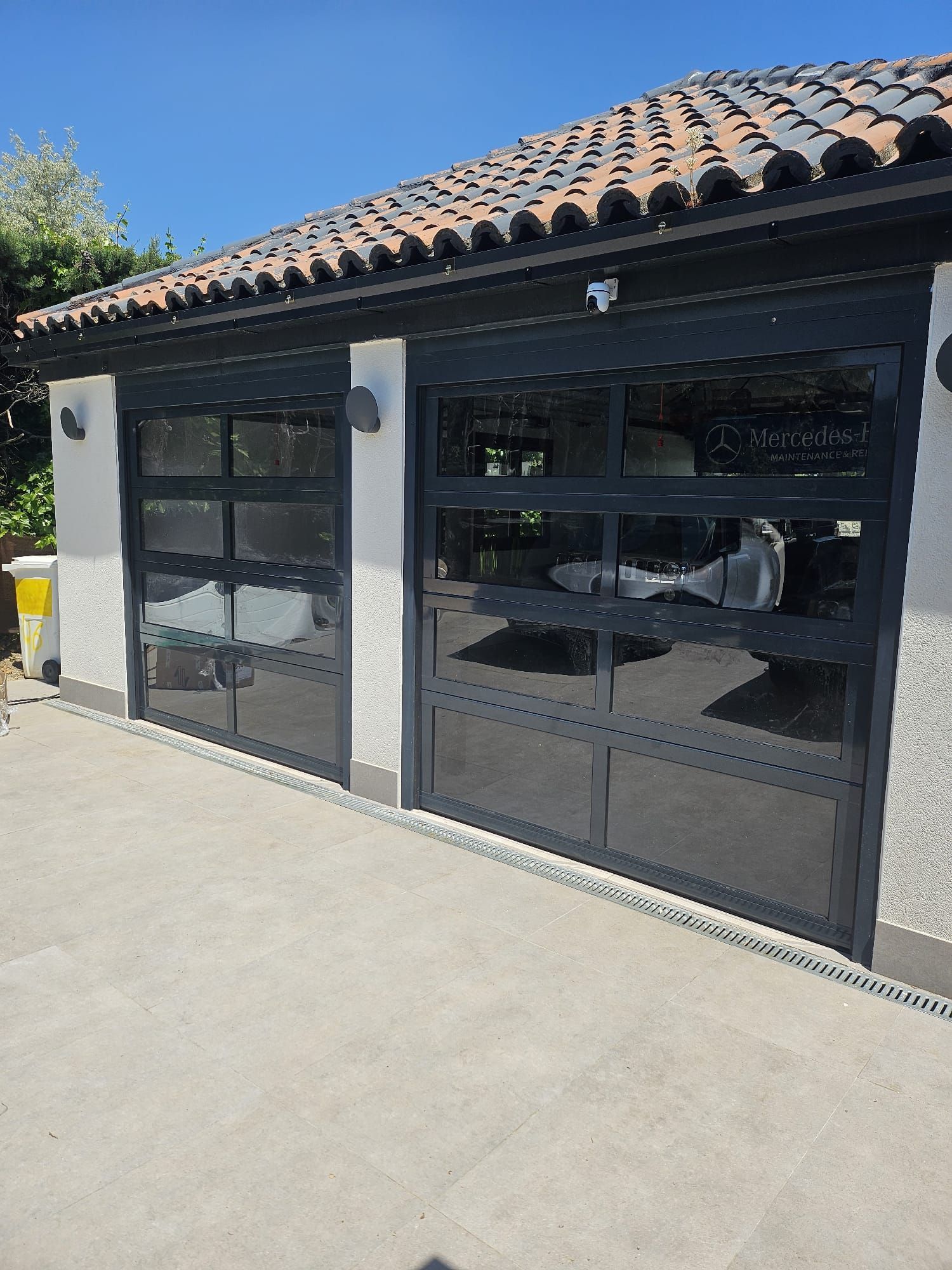 Un garaje con muchas ventanas y un coche aparcado en él.