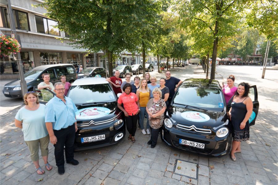 Gruppenfoto des Teams mit Dienstwagen