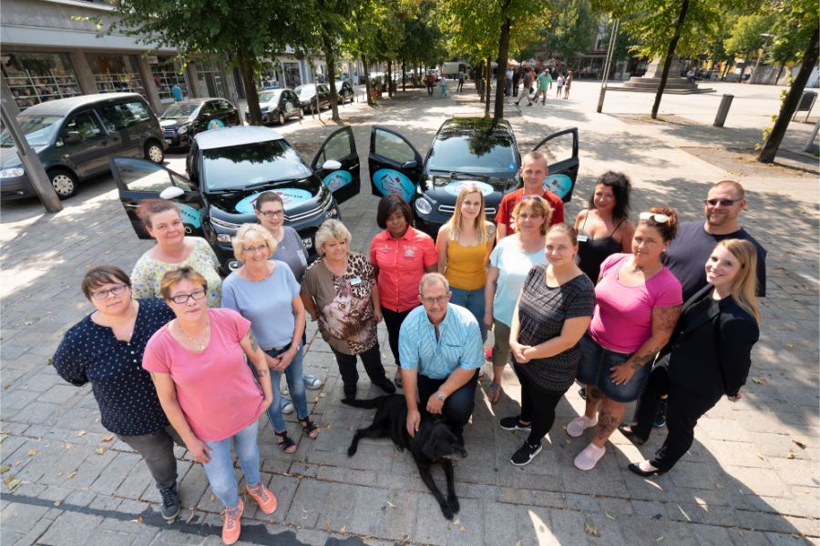 Pflegeteam vor den Dienstwagen