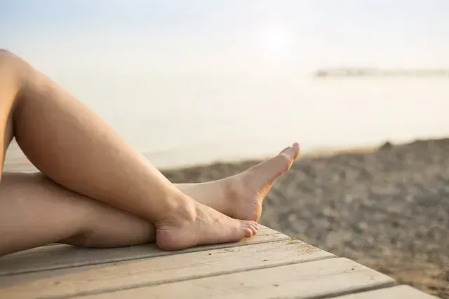 Una mujer está tumbada en un muelle de madera con las piernas cruzadas.