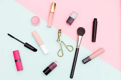 Hay muchos tipos diferentes de productos de maquillaje sobre un fondo rosa y azul.