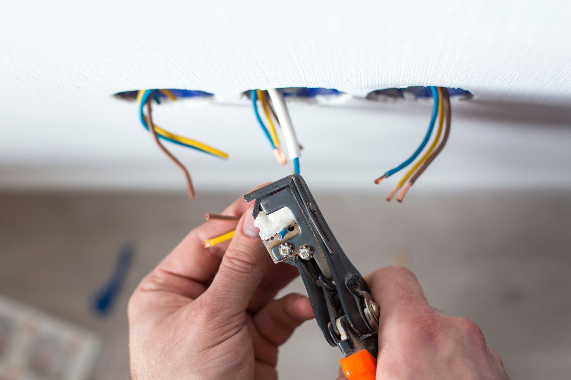 3 sorties de fils électriques dans du placo - un électricien dénude des fils