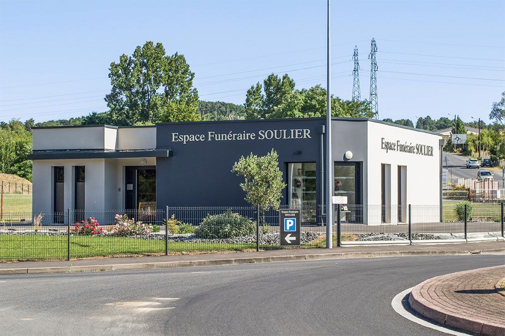 Bâtiment funéraire, enseigne « Espace Funéraire SOULIER », vue extérieure. Structure moderne grise et blanche, journée ensoleillée.