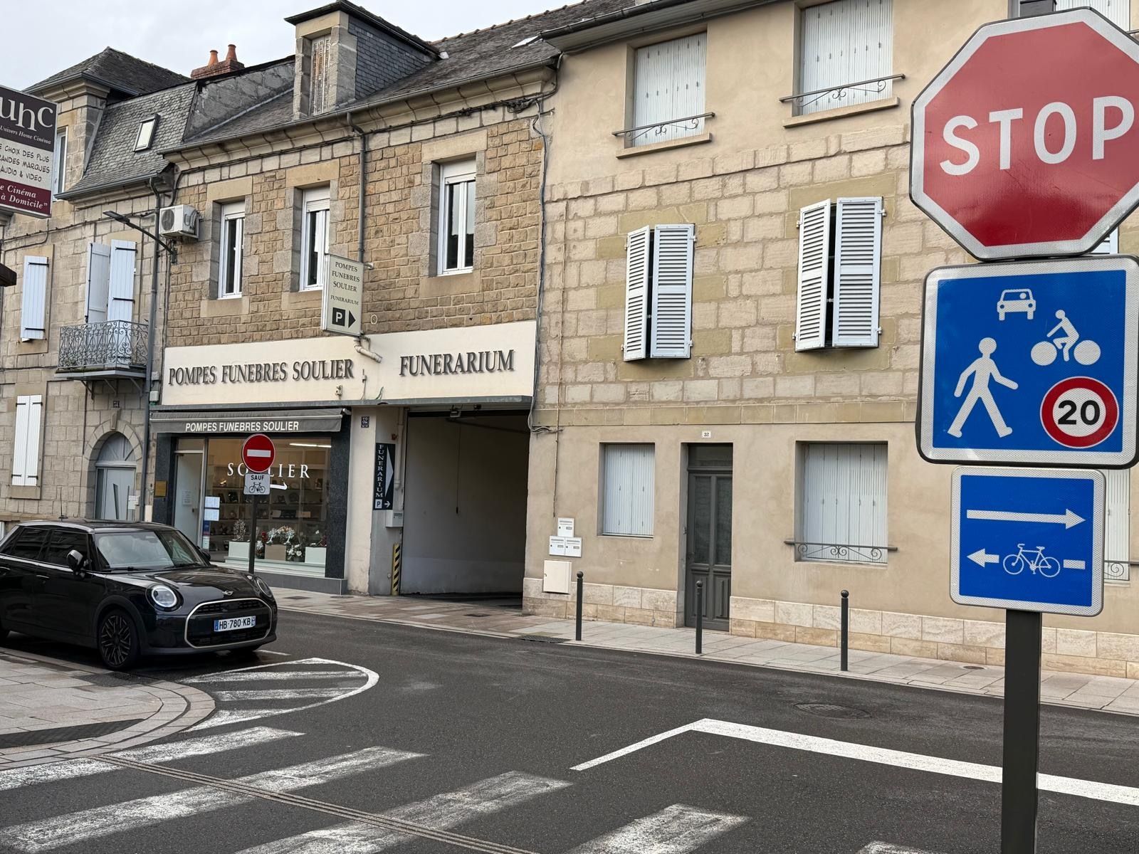 Intérieur d'une chapelle funéraire avec un cercueil, des chaises et un arbre en pot. Mur d'accent bleu.