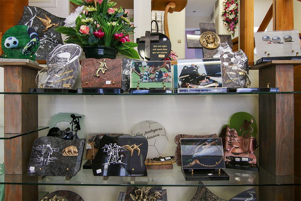 Étagère présentant diverses pierres tombales et monuments commémoratifs gravés.