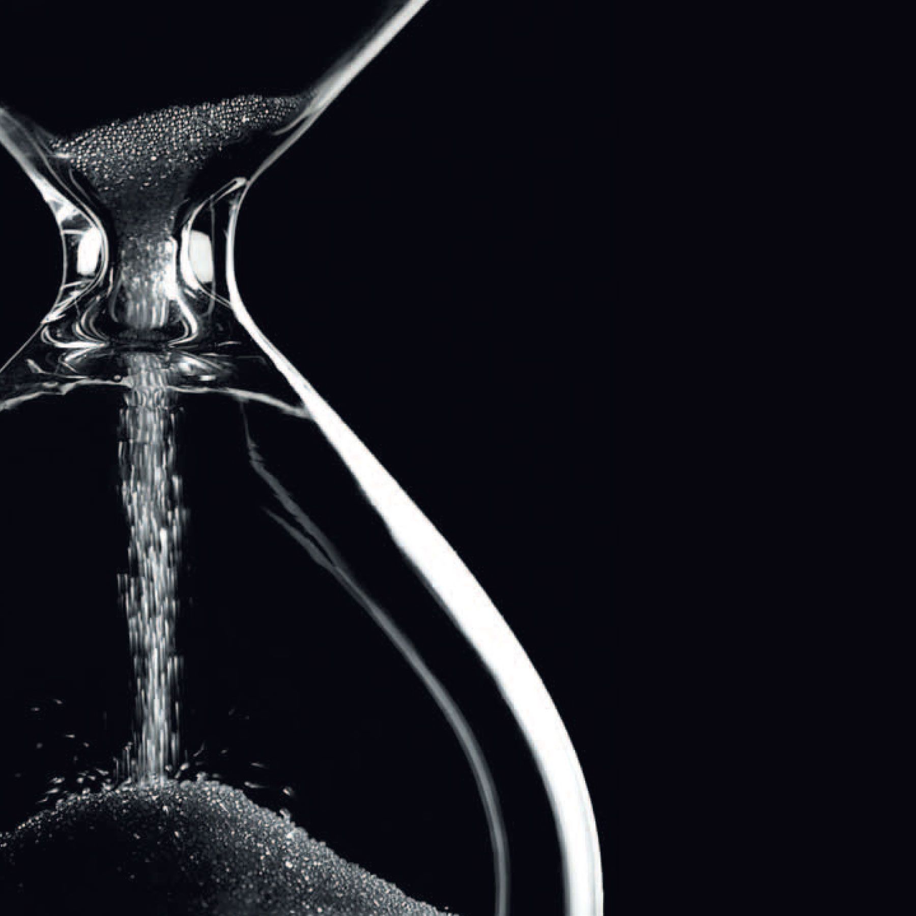 Sablier dont le sable s'écoule de haut en bas, sur fond noir.