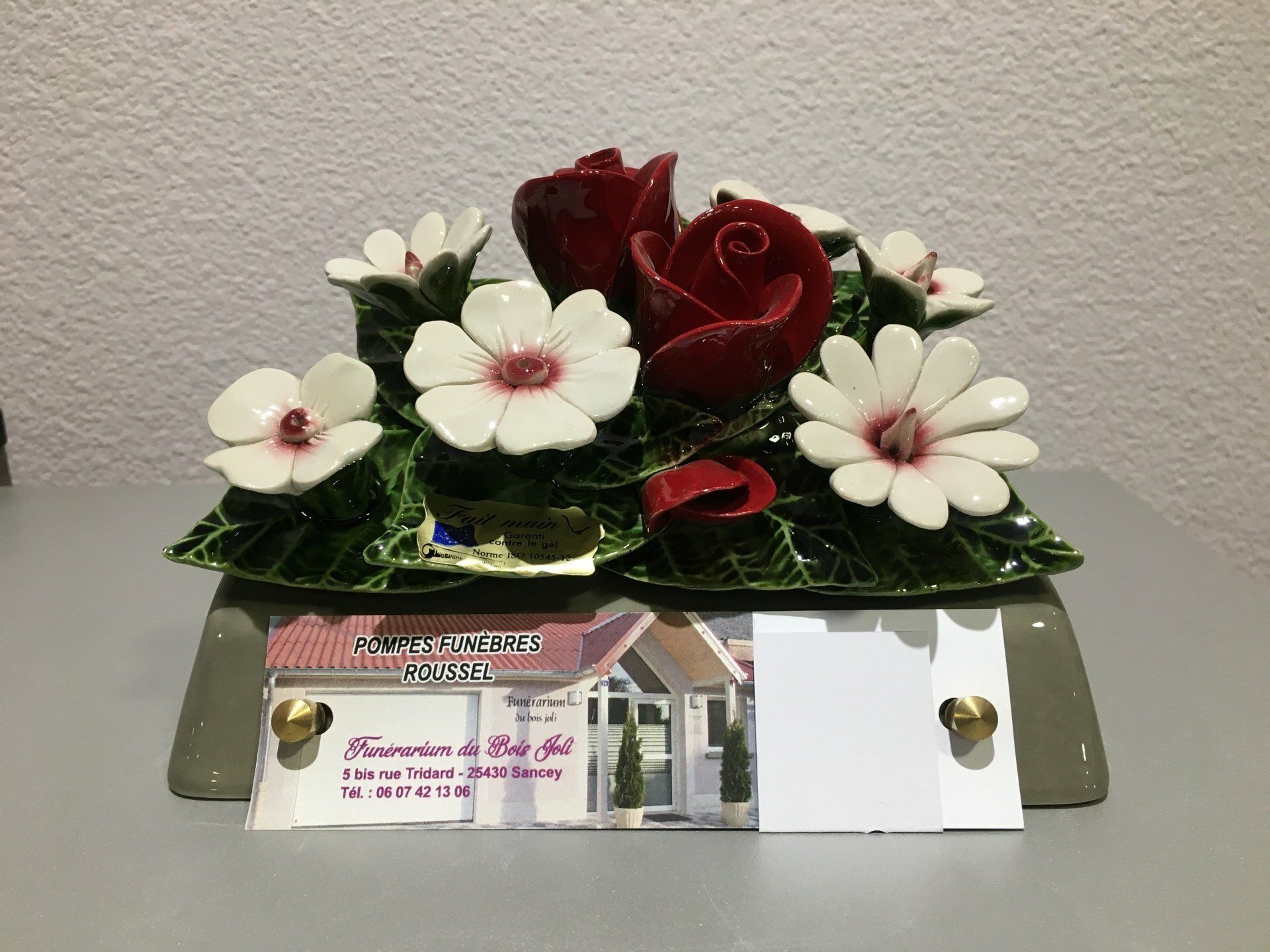 Composition de marguerites et roses artificielles.