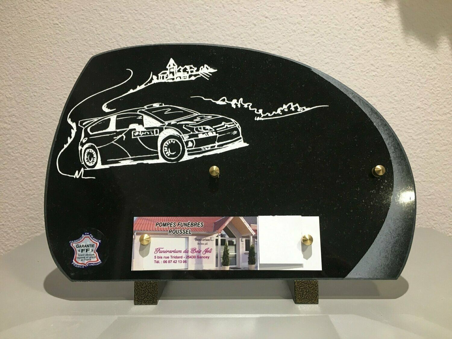 Plaque funéraire avec une voiture gravée.