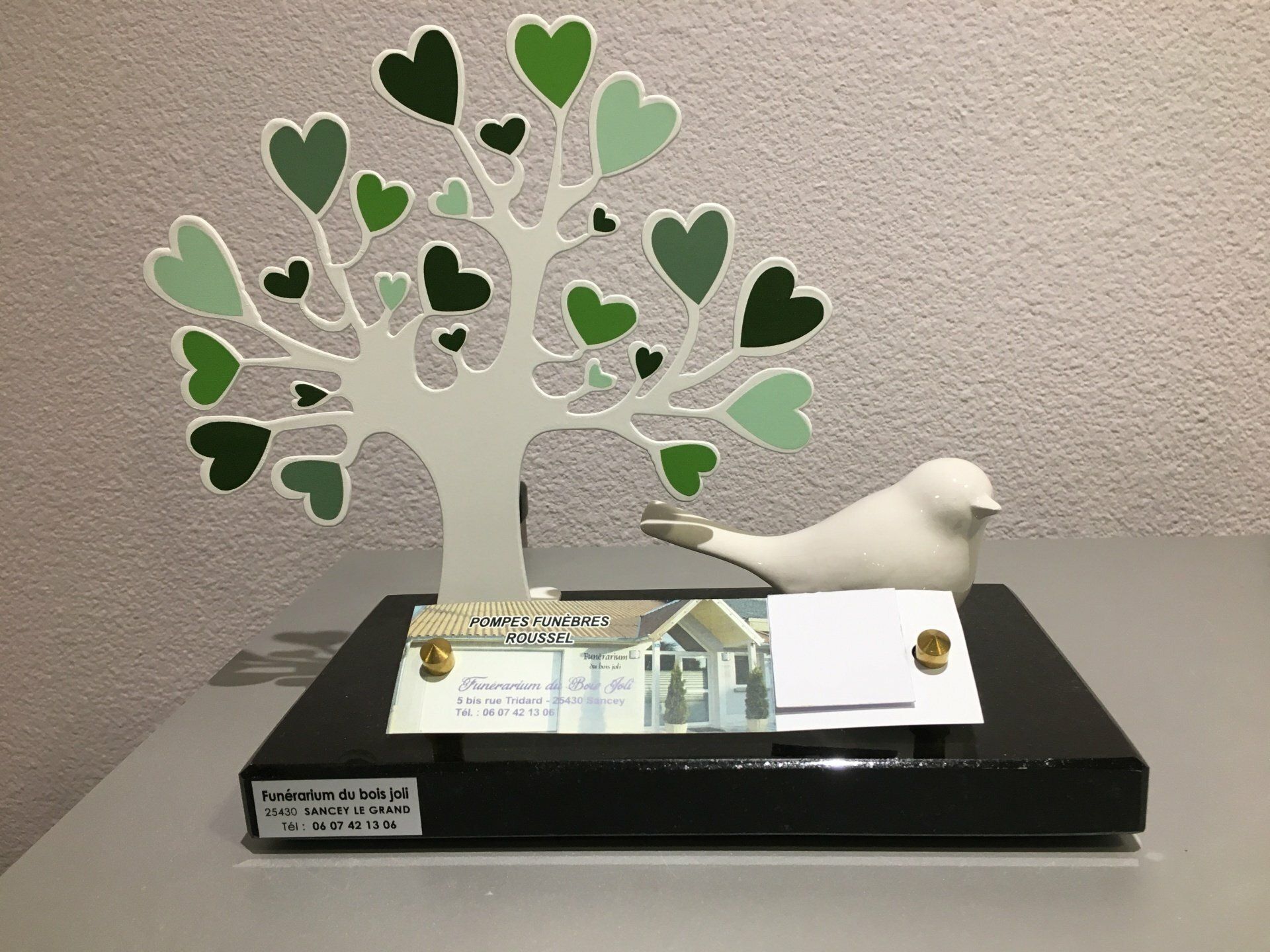 Une plaque funéraire en forme d'arbre et un oiseau.