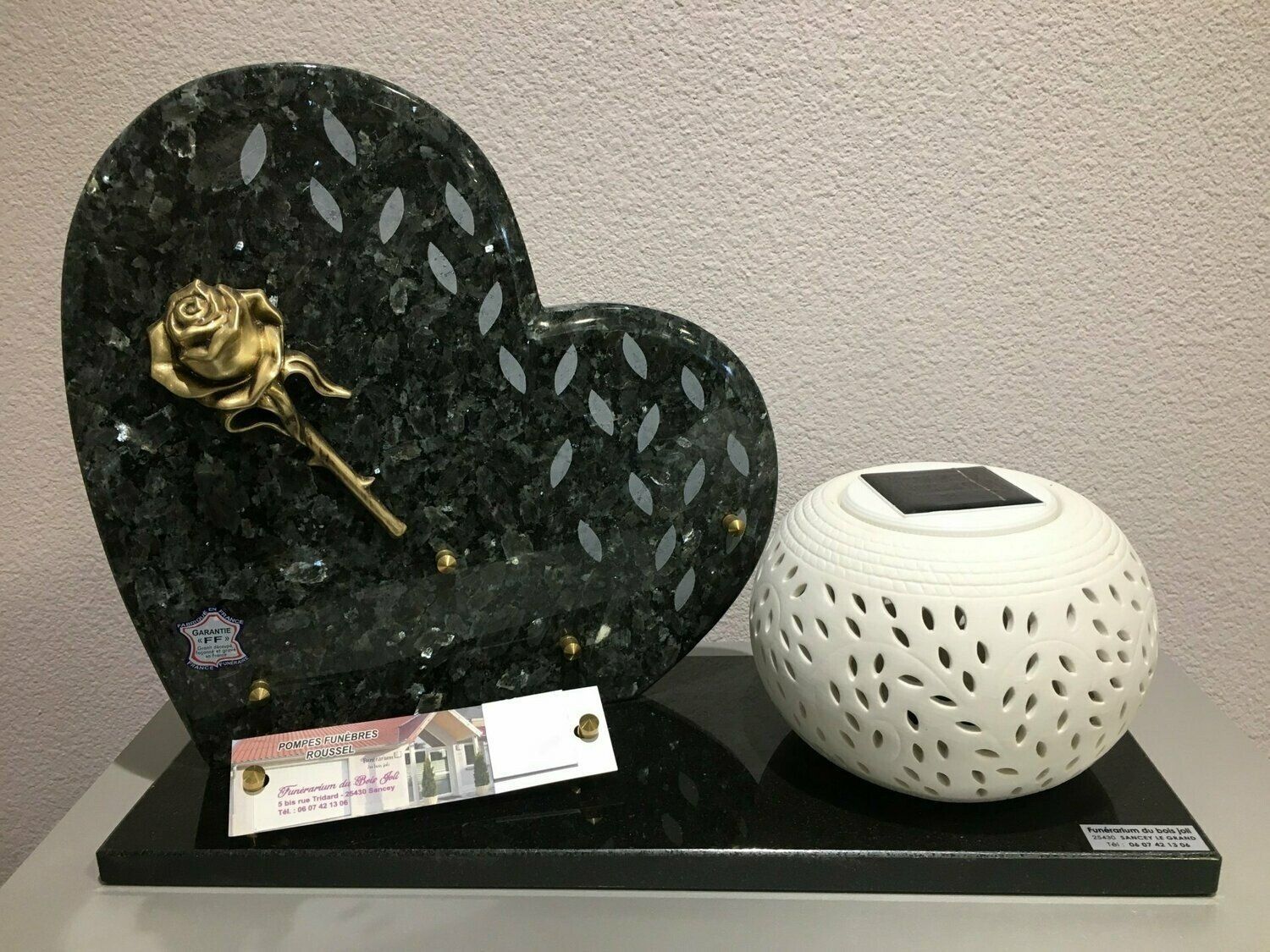 Une plaque funéraire en forme de cœur et une lanterne.