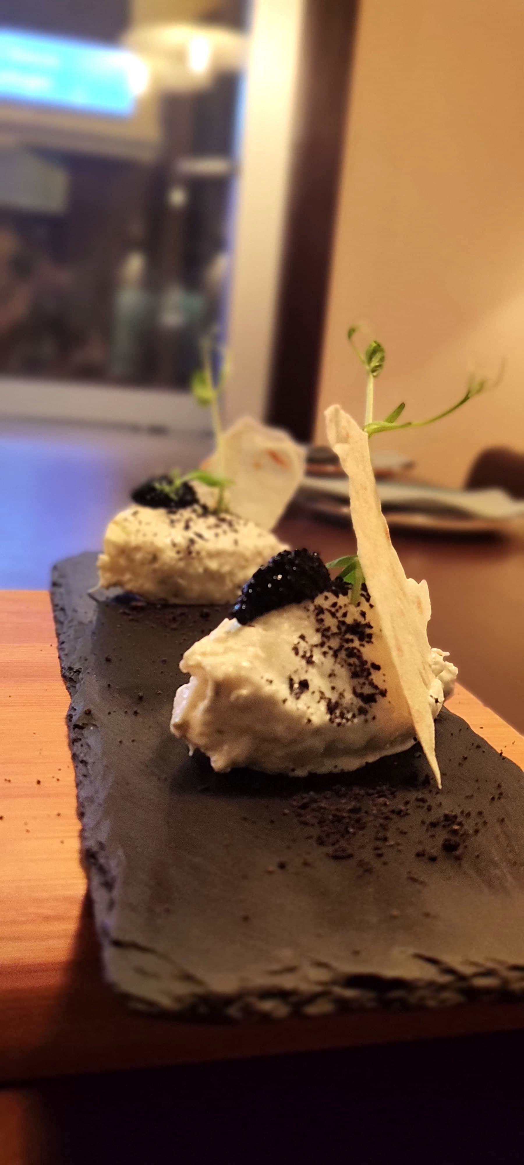 Un sándwich con jamón y queso en un plato negro.